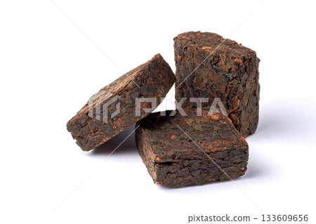 Three pieces of pressed fermented black tea isolated on white background. 133609656