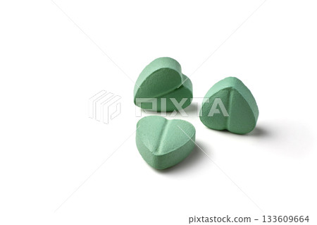 Turquoise heart-shaped cardiology pills isolated on white background. 133609664
