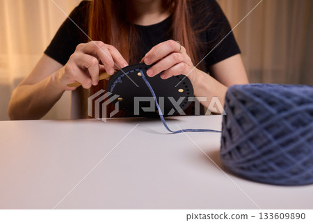 Crochet workshop scene, Artisan at work with yarn, Cozy crafting space with textured handmade stitches, Quiet studio environment dedicated to knitting and crochet crafts today Crochet workshop scene, Artisan at work with yarn, Cozy crafting space with textured handmade stitches, Quiet studio environment dedicated to knitting and crochet crafts today 133609890