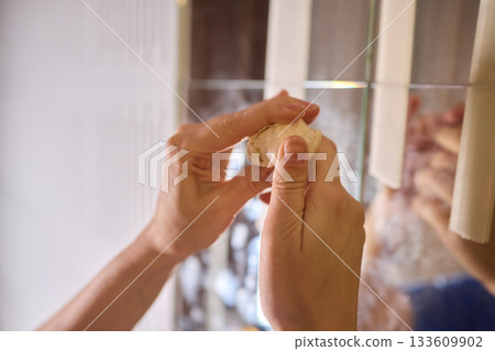 Final touch on reflective surface, Applying sponge to seal mirror tape in home renovation, Using sponge to smooth and seal mirror edge during home makeover process 133609902