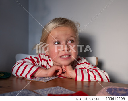 4 year old girl sitting at the table waiting for lunch. she is hungry 133610309