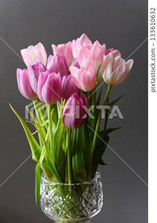A stunning floral arrangement of fresh pink and white tulips in a beautifully designed crystal vase A stunning floral arrangement of fresh pink and white tulips in a beautifully designed crystal vase 133610632
