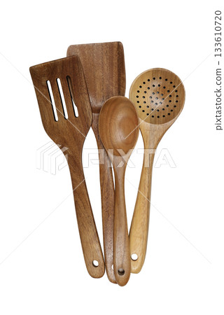 A set of four beautifully crafted wooden kitchen utensils, including spoons and spatulas, arranged together on a white background 133610720
