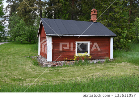 a charming traditional red wooden cottage nestled in the Finnish countryside 133611057