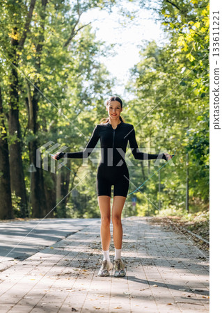 Endurance exercise, using jumping rope. Young sportive skinny woman is in black fitness clothes outdoors Endurance exercise, using jumping rope. Young sportive skinny woman is in black fitness clothes outdoors 133611221