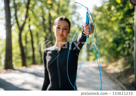 Young sportive skinny woman is in black fitness clothes outdoors 133611233