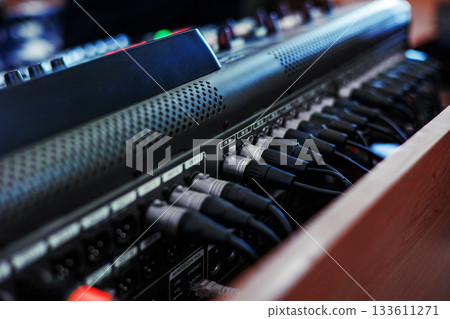 Rear console of control panel for equipment with connection cables to connect the equalizer, amplifier, microphones, speakers and other musical instruments. Connections of professional sound system. 133611271
