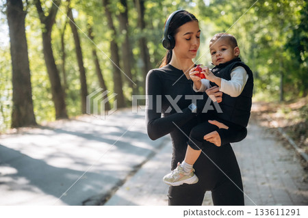 Standing together. Mother with her little son is outdoors. In sportive clothes 133611291