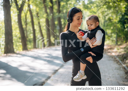 Mother with her little son is outdoors. In sportive clothes Mother with her little son is outdoors. In sportive clothes 133611292