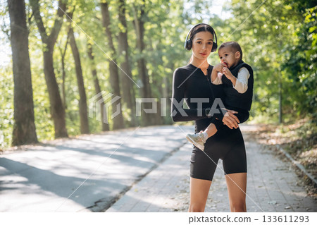 Mother with her little son is outdoors. In sportive clothes Mother with her little son is outdoors. In sportive clothes 133611293