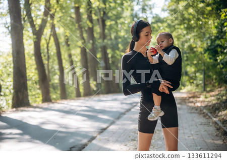 Mother with her little son is outdoors. In sportive clothes Mother with her little son is outdoors. In sportive clothes 133611294