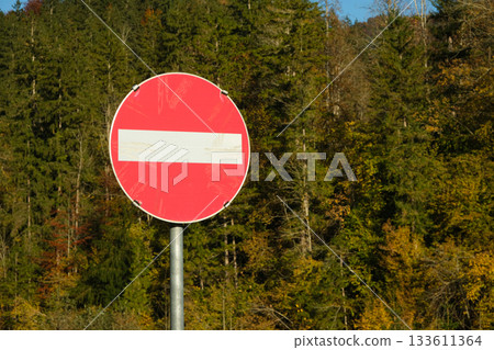 Do Not Enter Road Sign Against a Natural Forest Background, No Entry Do Not Enter Road Sign Against a Natural Forest Background, No Entry 133611364