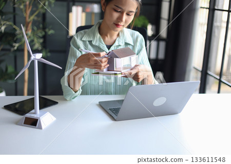 Female engineer working in office design eco friendly and sustainable living home. Female engineer working in office design eco friendly and sustainable living home. 133611548