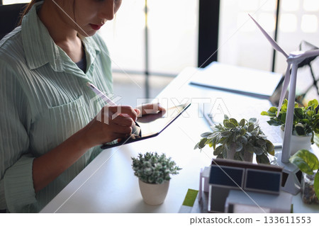 Female engineer working in office design eco friendly and sustainable living home. Female engineer working in office design eco friendly and sustainable living home. 133611553