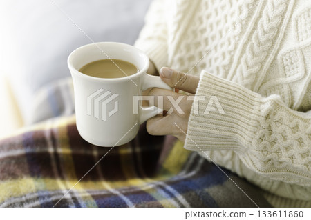 Woman's hands holding cafe au lait on her lap (relaxing in winter) Woman's hands holding cafe au lait on her lap (relaxing in winter) 133611860