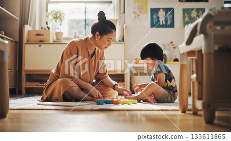 A warm moment as mother and child enjoy playing with building blocks in the gentle light 133611865