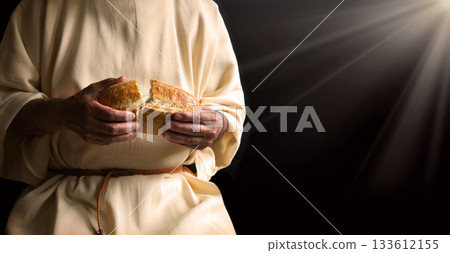 Man's hans holding fresh bread 133612155
