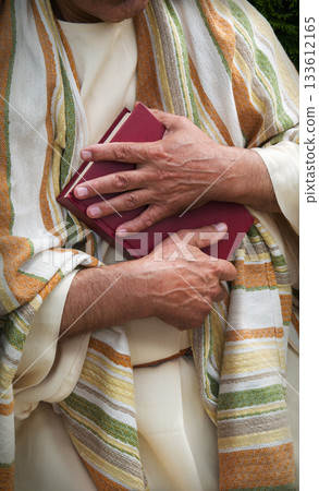 Old man holding red book 133612165