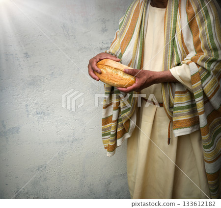 Man's hans holding fresh bread 133612182