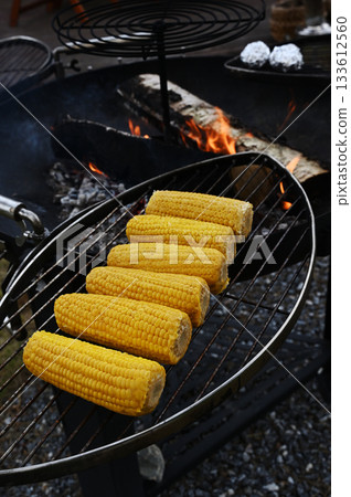 Fresh corn on the cob roasting on a metal grill 133612560