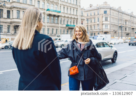 Two female friends met and joyfully hugged each other 133612907