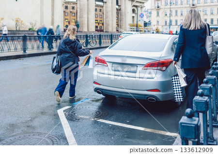 Two women hail taxi after leaving store with shopping bags 133612909