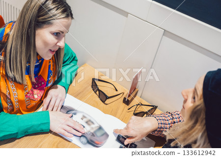 Two beautiful girls met in cafe, talked and read newspapers Two beautiful girls met in cafe, talked and read newspapers 133612942