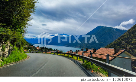 A road along the shore of Lake Como in Italy on a sunny day. Traveling to tourist destinations in Italy 133613075