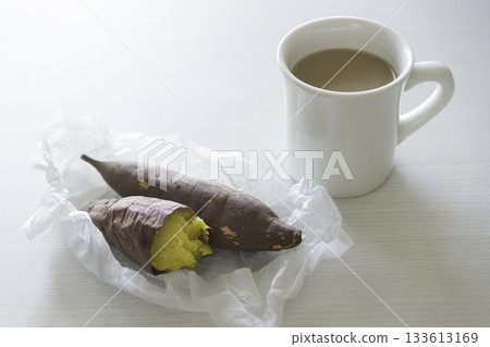 Roasted sweet potato and a mug of cafe au lait placed on a white table Roasted sweet potato and a mug of cafe au lait placed on a white table 133613169