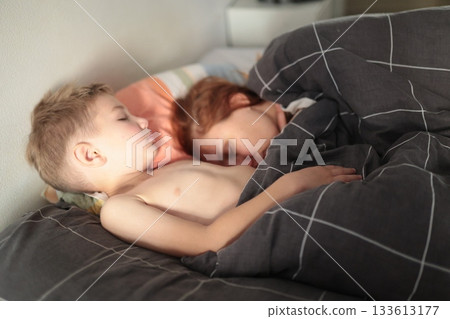 Young children sleeping peacefully together in bed 133613177