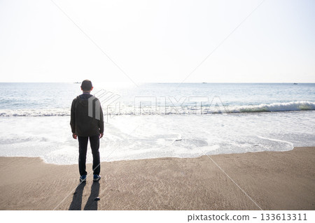 一個男人的剪影,他站著,望著大海。 一個男人的剪影,他站著,望著大海。 133613311