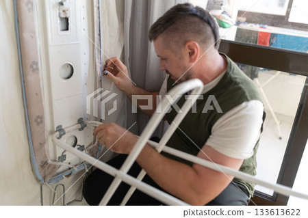 Man working on airplane interior panel wiring 133613622