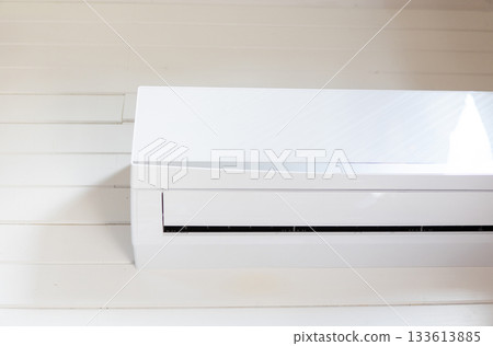 Air conditioning unit close up on white wooden wall interior background Air conditioning unit close up on white wooden wall interior background 133613885