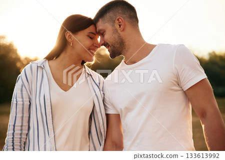 Looking at each other. Beautiful couple is in love, standing on the field together Looking at each other. Beautiful couple is in love, standing on the field together 133613992