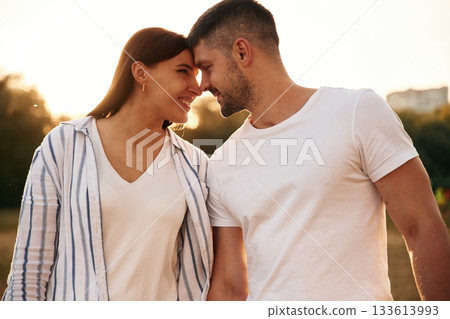 Looking at each other. Beautiful couple is in love, standing on the field together Looking at each other. Beautiful couple is in love, standing on the field together 133613993
