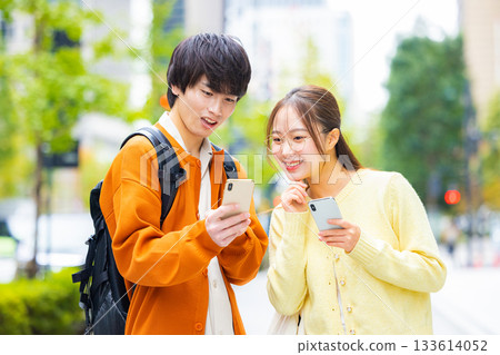 城市裡的年輕男女都在看智慧型手機。 城市裡的年輕男女都在看智慧型手機。 133614052