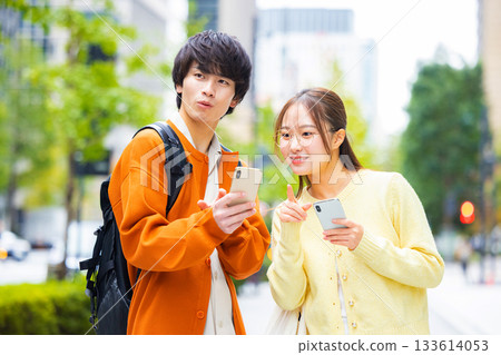 城市裡的年輕男女都在看智慧型手機。 城市裡的年輕男女都在看智慧型手機。 133614053