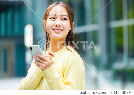 Woman holding a smartphone 133614059