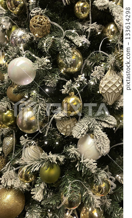 Luxury shiny Christmas tree with golden and metallic balls, pine cones, leaves and lights garland. Xmas holiday pattern. Trendy and creative design. 133614298
