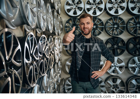 Thumb up, gesture. Man worker is maintenance station with tires, wheels Thumb up, gesture. Man worker is maintenance station with tires, wheels 133614348