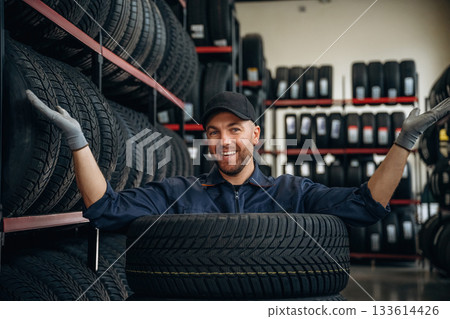 Inside of the wheels, having fun. Man worker is maintenance station with tires 133614426