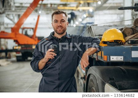 Having a break, with cup of drink. Male worker is in the modern warehouse or manufacturing company Having a break, with cup of drink. Male worker is in the modern warehouse or manufacturing company 133614682