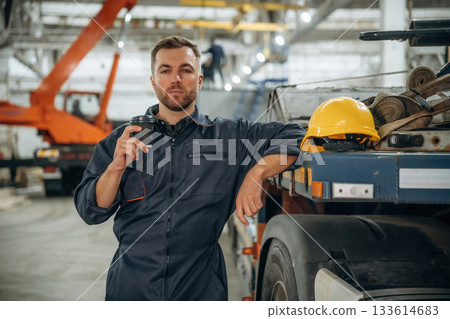 Having a break, with cup of drink. Male worker is in the modern warehouse or manufacturing company Having a break, with cup of drink. Male worker is in the modern warehouse or manufacturing company 133614683
