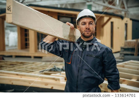 Male builder is at construction of wooden house 133614701