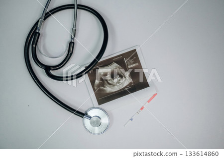 Stethoscope is there. Picture of ultrasonic test is on the white table, conception of healthcare Stethoscope is there. Picture of ultrasonic test is on the white table, conception of healthcare 133614860