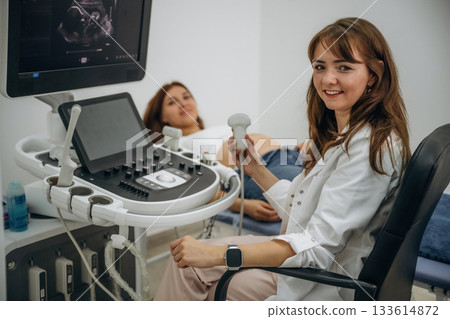 Cheerful facial expression. Pregnant woman undergoing ultrasound test 133614872
