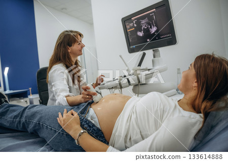 With big belly. Pregnant woman undergoing ultrasound test With big belly. Pregnant woman undergoing ultrasound test 133614888