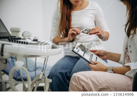 Documents, results of scan in notepad. Pregnant woman undergoing ultrasound test 133614906