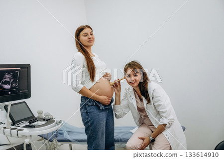 Just listening by using a tool, belly. Pregnant woman with doctor, woman is listening the stomach 133614910