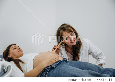 Just listening by using a tool, belly. Pregnant woman with doctor, woman is listening the stomach 133614911